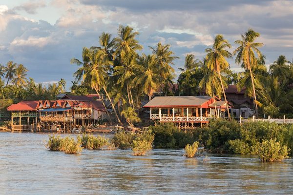 River bank of Don Khon with stilt wooden houses at golden hour from Don Det Laos