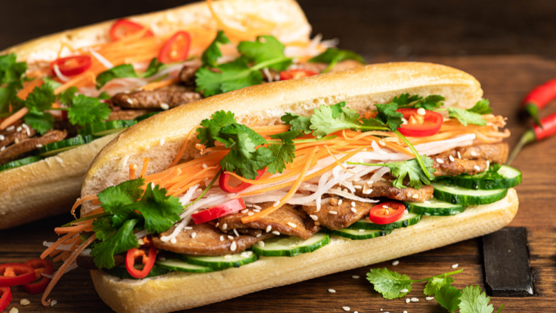 Hanoi Old Quarter street food stalls with tourists enjoying local dishes