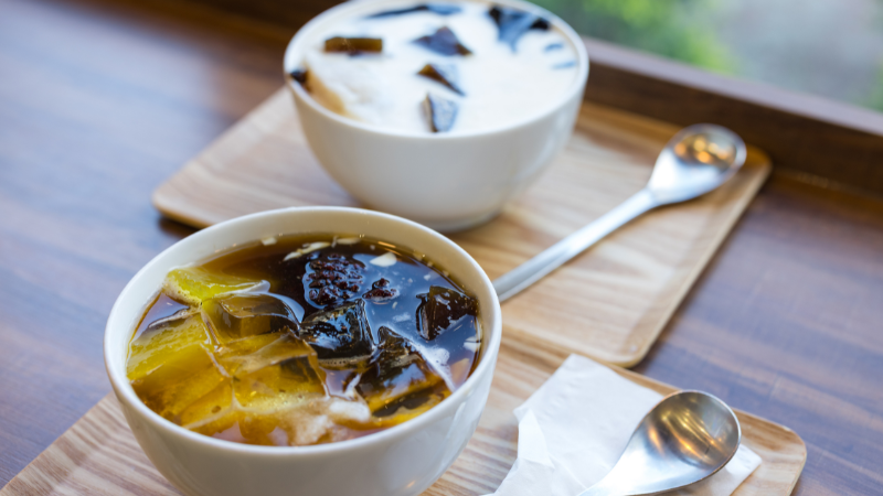 Bowl of Hanoi tofu pudding topped with syrup and coconut